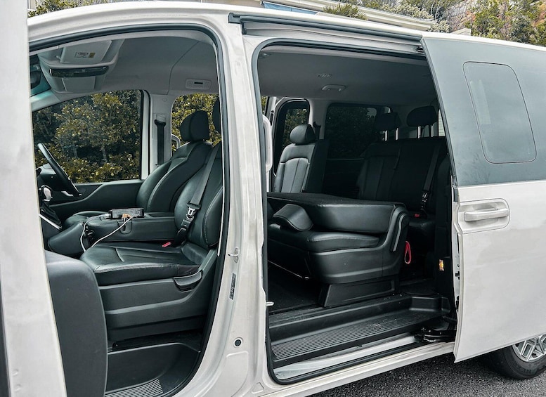 A white van with black interior, open door, and visible steps leading to the cargo area. 2