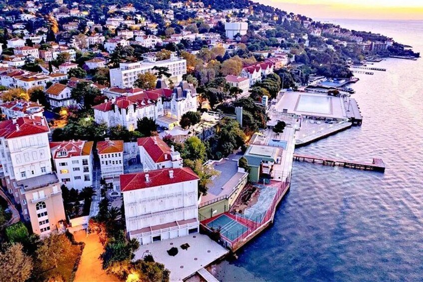 A coastal cityscape with buildings, a dock, and a body of water. 2