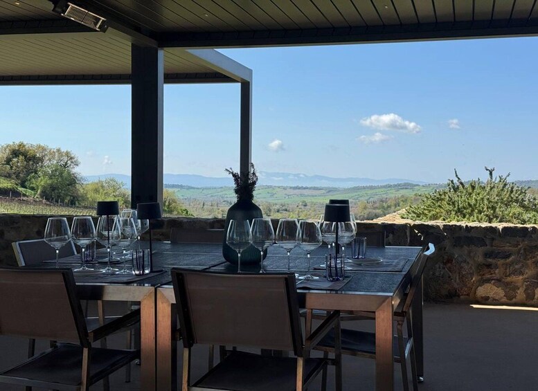 A table set for dining with a view of rolling hills and vineyards. 4