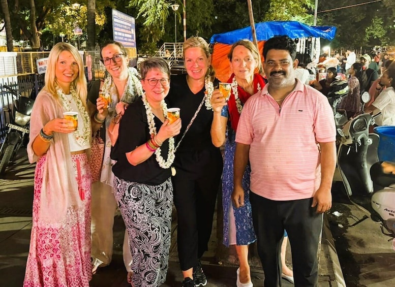 A group of people at an outdoor event, some holding drinks. 5