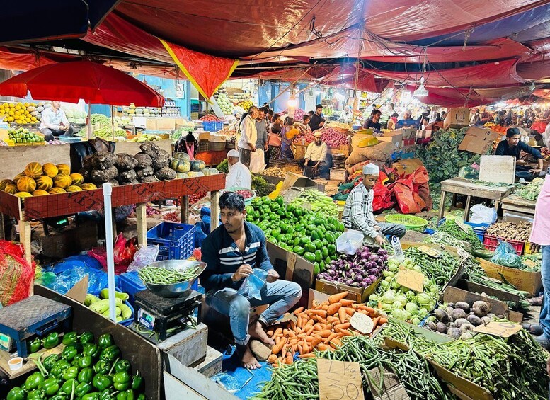 A bustling outdoor market with various stalls selling fresh produce like vegetables and fruits. 3