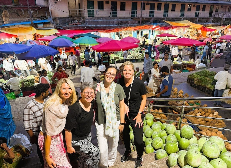 A bustling outdoor market with colorful umbrellas and various stalls selling fruits and vegetables. 4