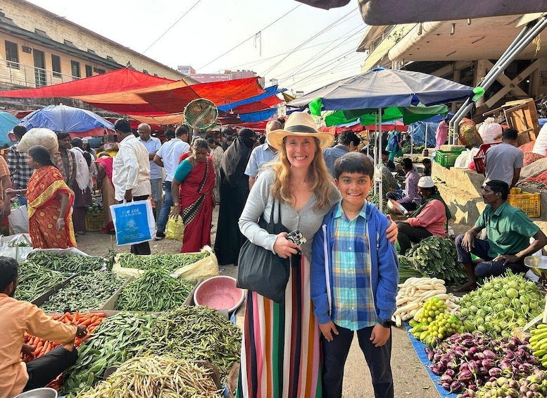 A bustling outdoor market with people shopping and vendors selling vegetables. 2
