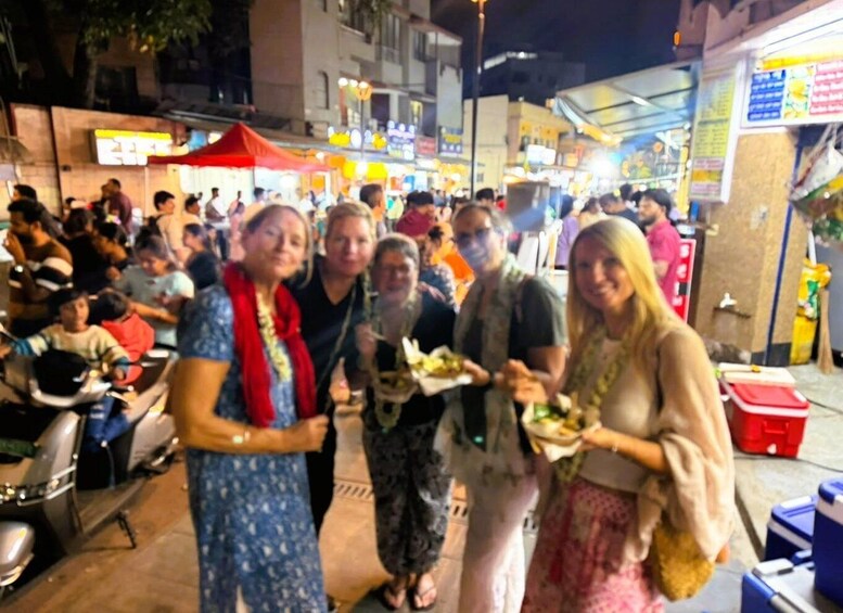 A crowded street market at night with people dining and shopping. 3