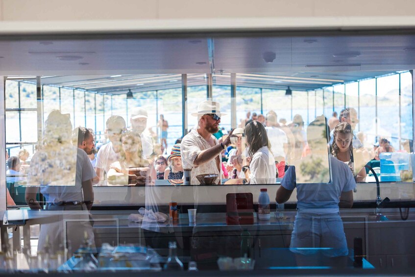 A busy outdoor café with people dining and a waiter serving. 5
