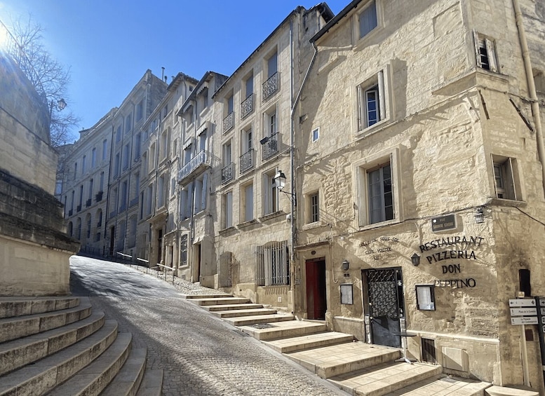 A cobblestone street with historic buildings, a staircase leading to a restaurant named 'RESTAURANT PIZZERIA DON PEPPINO,' and a clear blue sky. 2