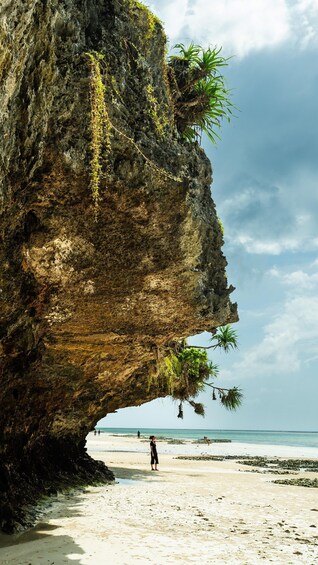 Una gran formación rocosa con un arco natural sobre una playa. 1