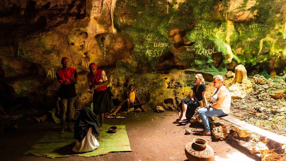 Un grupo de personas en una cueva con grafitis en las paredes. 5