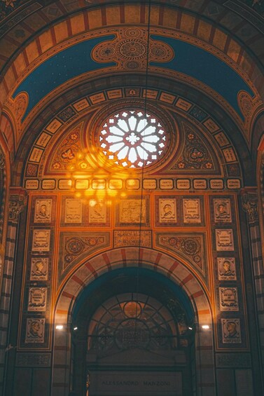 A grand arched ceiling with intricate designs and a large stained glass window. 4