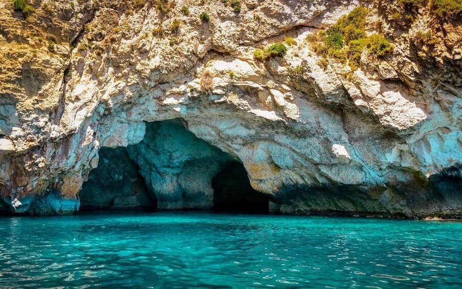 A coastal cave entrance with clear turquoise water. 4