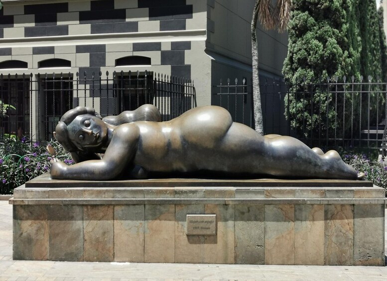 A bronze sculpture of a reclining figure on a pedestal, with a plaque indicating it is from 1987. 5
