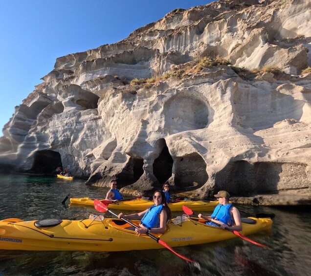 People kayaking in a cove with rocky cliffs. 2