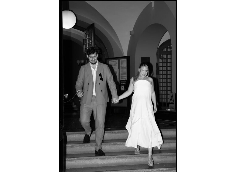 A man and a woman holding hands walking down a staircase. 5