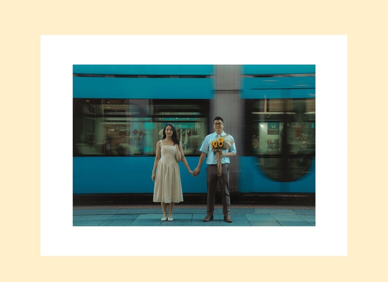 A couple holding hands in front of a moving train. 5