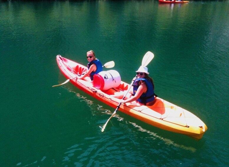Two people kayaking on a calm lake. 1