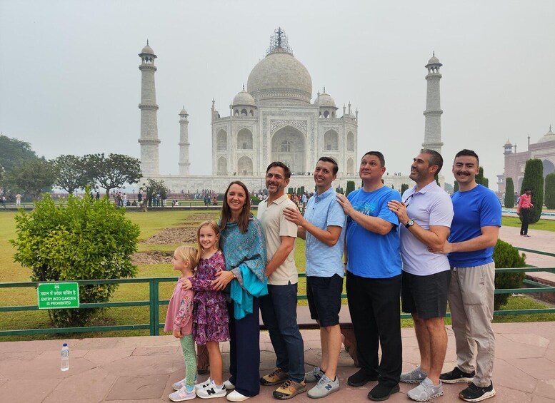 A group of people standing in front of the Taj Mahal. 5