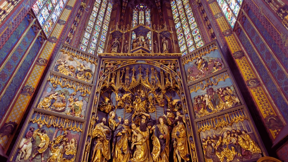 A richly decorated Gothic cathedral interior with intricate stained glass windows and golden statues. 4