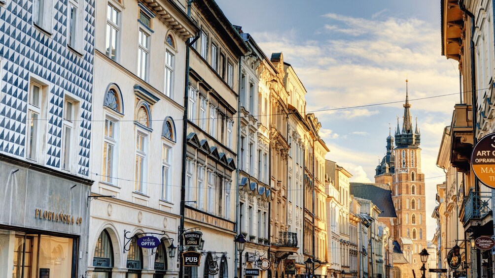 A street with historic buildings, a prominent church spire, and various commercial establishments. 5