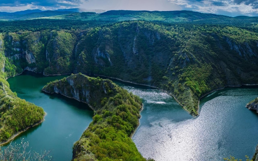 A river winding through a mountainous landscape with dense greenery and rocky cliffs. 3