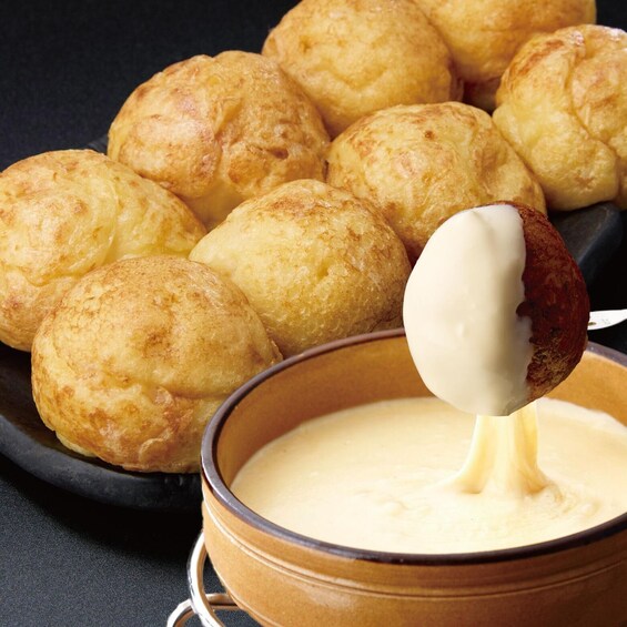 A bowl of cheese curds with a spoon. 3