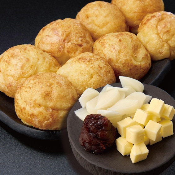 Golden-brown pastries on a plate, alongside cubes of butter and a piece of dark fruit. 5