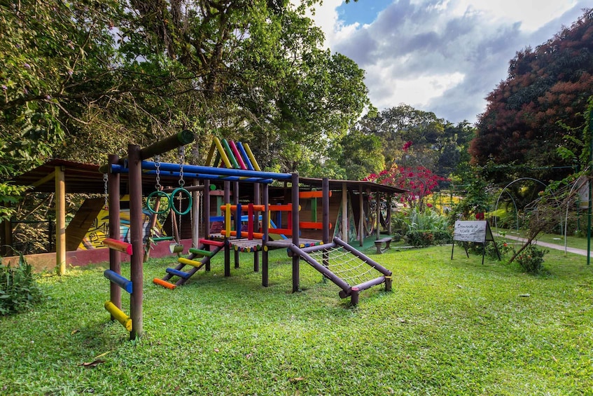 A playground with colorful equipment and a sign in a park. 4