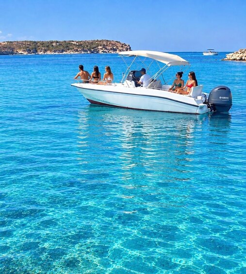 A white motorboat with a canopy on a clear blue sea. 2