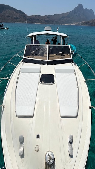 A boat with a white deck, two side seats, and a steering wheel. 2