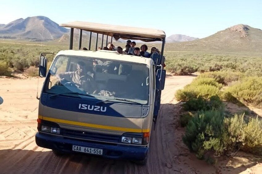 Un véhicule Isuzu transportant des passagers sur une route désertique. 2