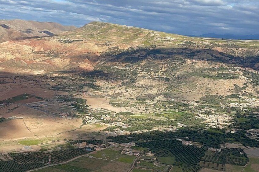 A mountainous landscape with scattered settlements, terraced fields, and a river. 5