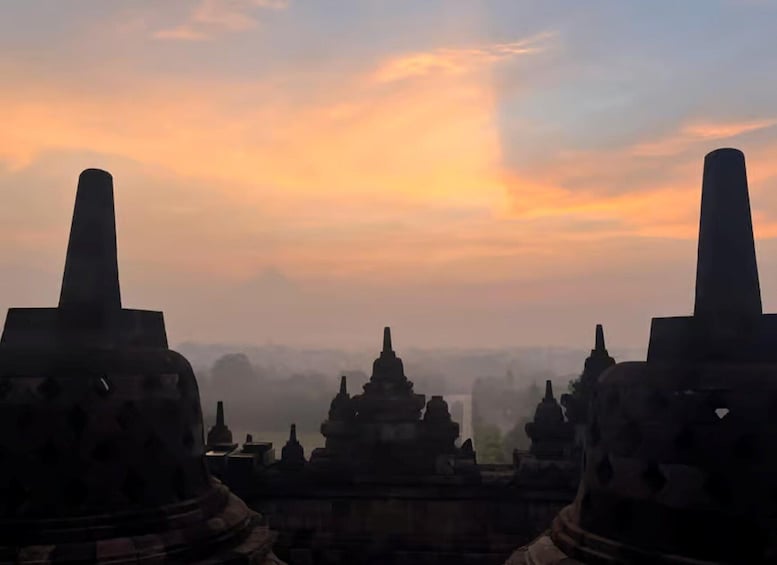 A temple complex with multiple spires silhouetted against a sunset sky. 4