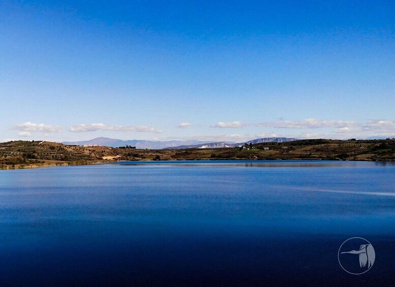 A large body of water with a clear sky and distant mountains. 4