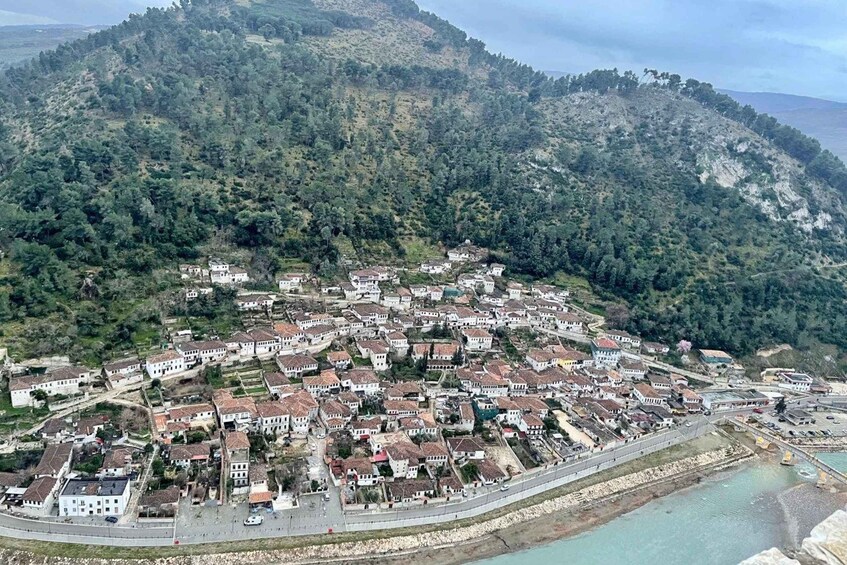 A coastal town with white buildings, a road, and a beach. 2