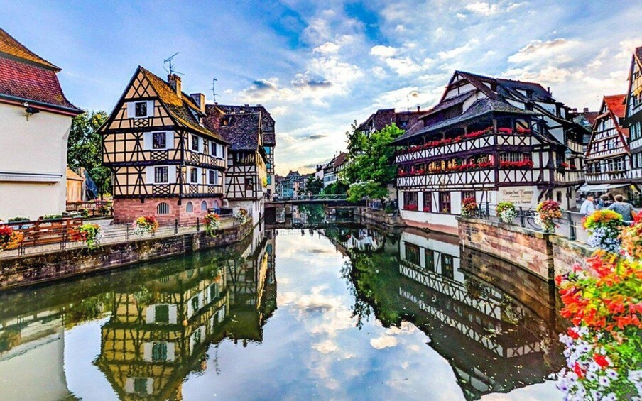 A canal with traditional half-timbered houses on either side, reflecting in the water. 3