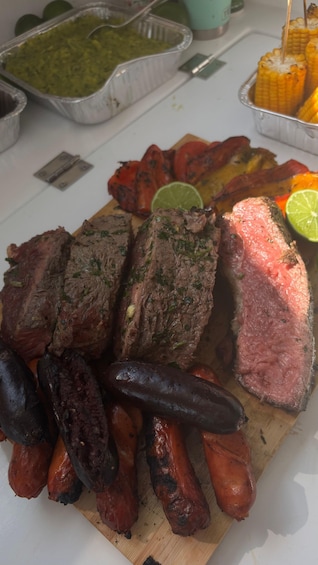 A variety of grilled meats including steak, sausages, and possibly chorizo, served on a wooden board with lime wedges. 4