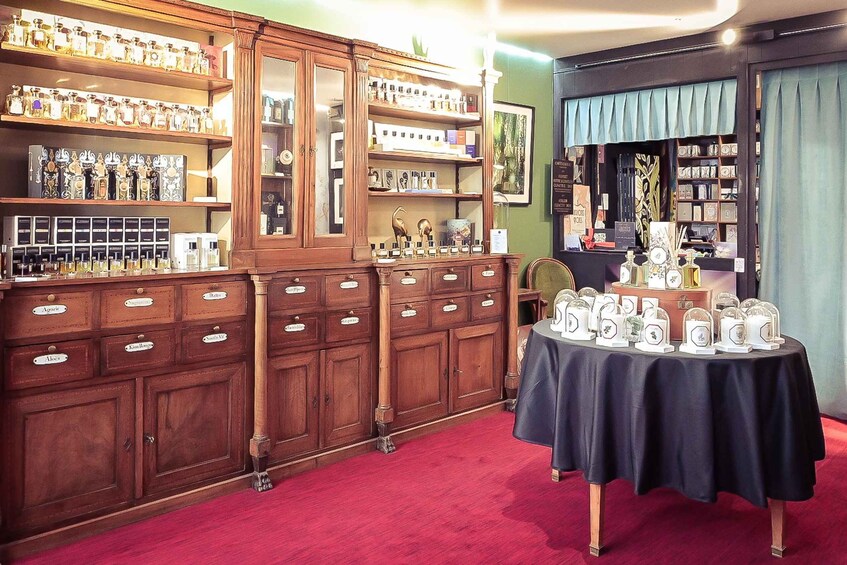 A vintage store with wooden cabinets and a table displaying perfume bottles. 5