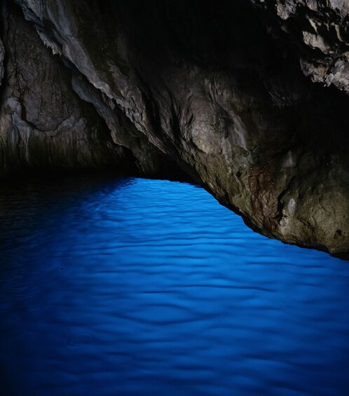 A cave with a pool of blue water. 5