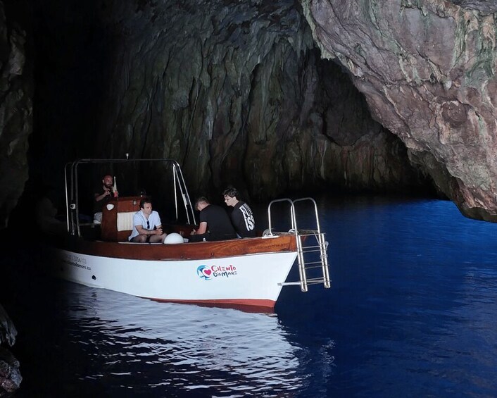 A boat with passengers, a ladder, and a cave entrance. 4