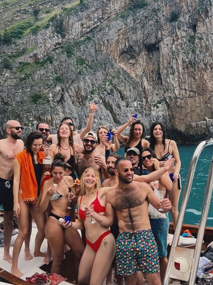 A group of people on a boat near rocky cliffs. 1