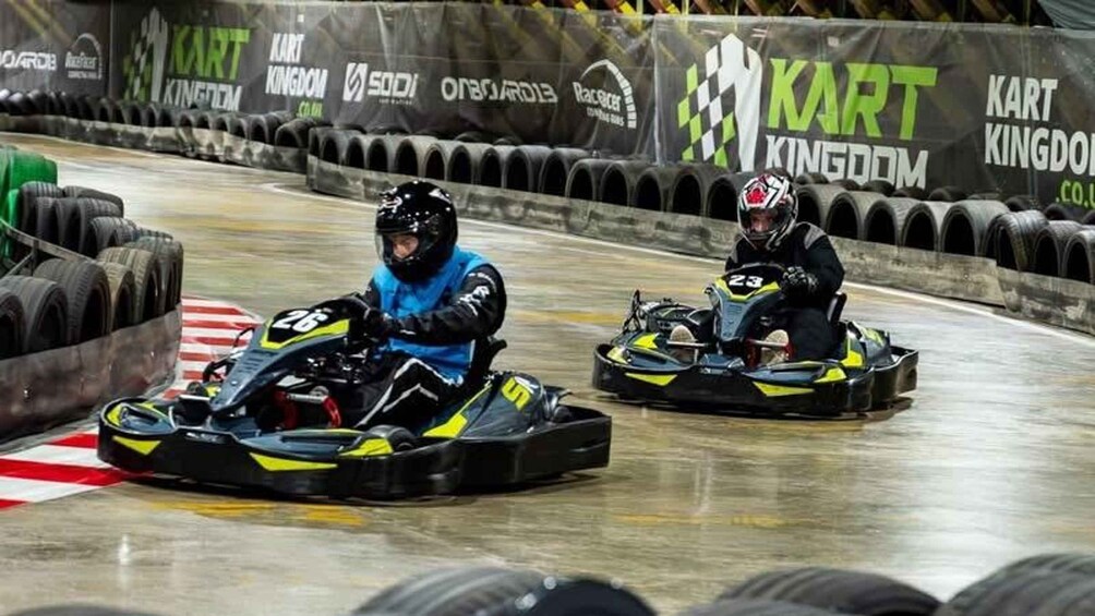 Two go-karts on a track with sponsor banners. 2