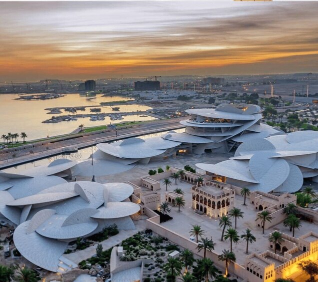 A modern architectural complex with circular structures and palm trees. 2