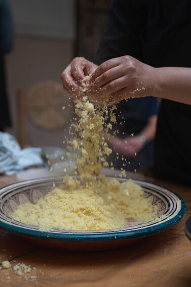 Hands sprinkling breadcrumbs onto a plate. 3