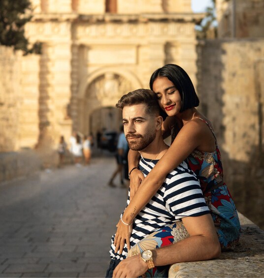 A couple embracing in front of an ancient stone archway. 1