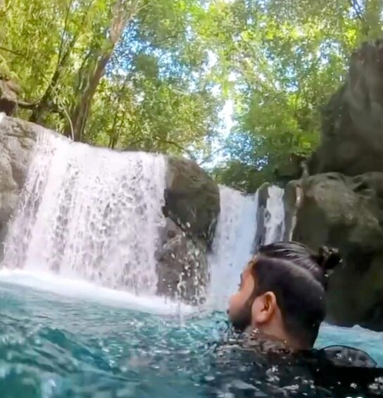 A waterfall, clear water, and greenery. 4