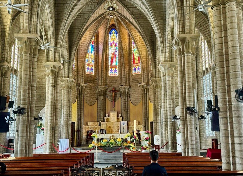 Interno di una cattedrale con soffitti a volta alti, vetrate colorate e un altare centrale. 2