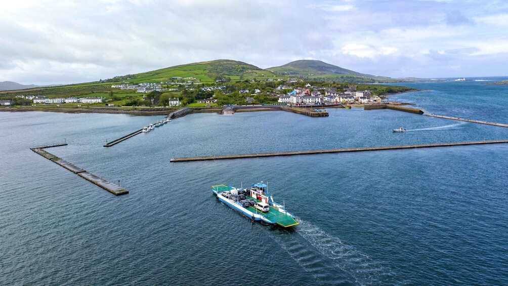 A ferry docked at a pier with a coastal town in the background. 2