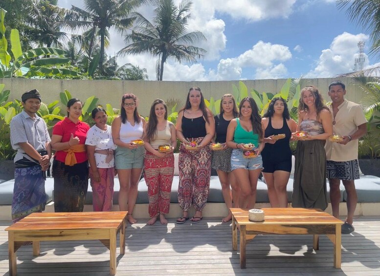 A group of people standing on a wooden deck with palm trees and a clear sky in the background. 2
