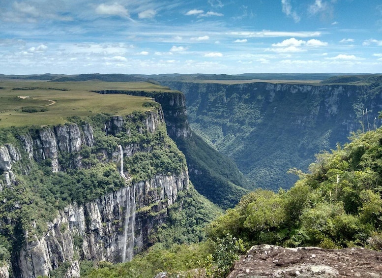 A deep canyon with steep cliffs and a waterfall. 5