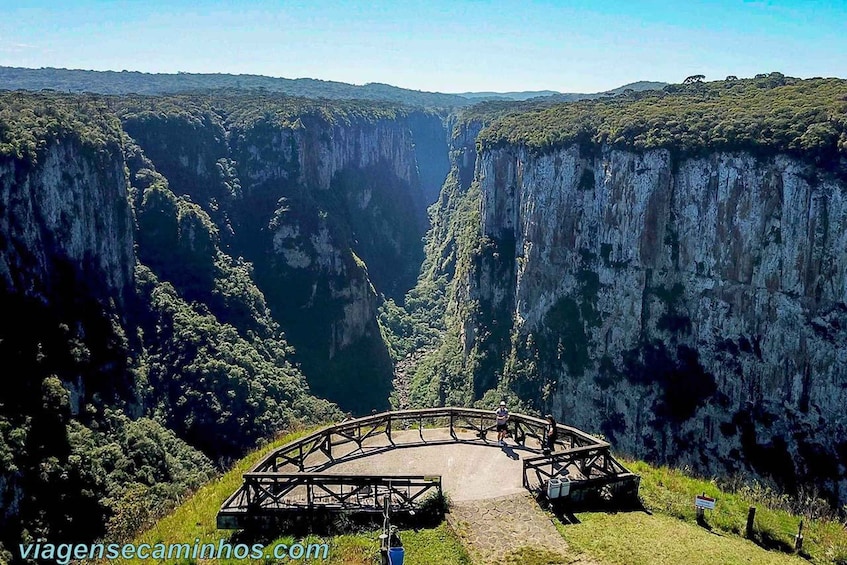 A scenic viewpoint overlooking a deep canyon with a wooden observation platform. 4