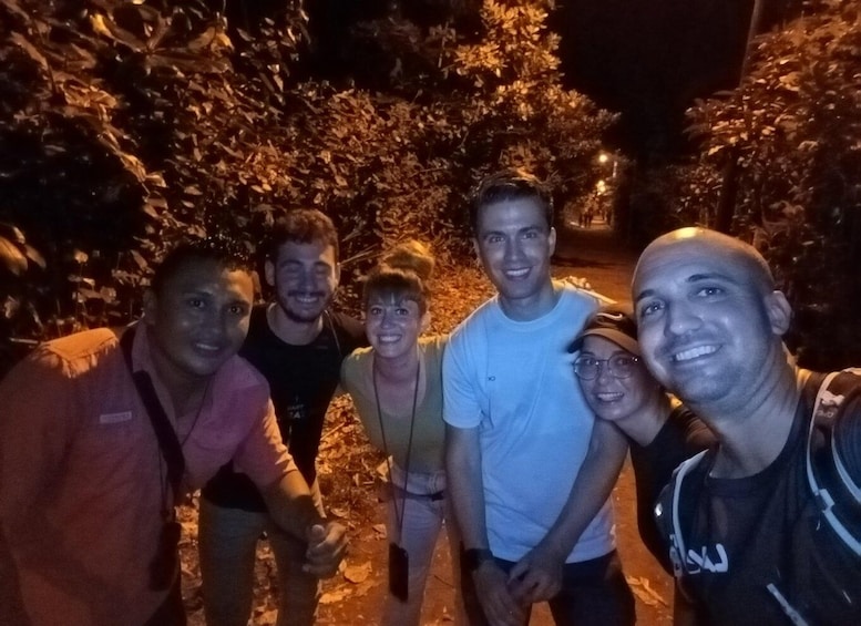 A group of people standing on a path surrounded by trees. 5